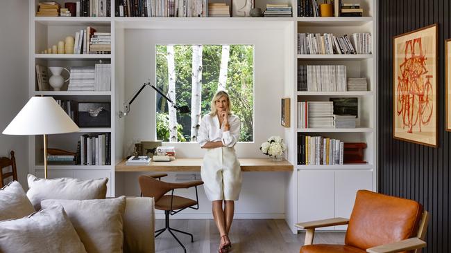 Oroton creative director Sophie Holt in her home office. Also shown: Getama Plank chair and footstool and J.T. Kalmar Hase floor lamp, all from Great Dane Furniture, GamFratesi for Gubi Masculo Meeting desk chair from Cult Design, Artemide Tolemeo lamp (on desk) and Lampe de Bureau lamp (on right bookshelf), both from In Good Company, Britt Neech artwork, Maison Martin Margiela Russian dolls and Emily Ellis ceramic white jug from Pepite (all on left bookshelf). Picture: Derek Swalwell