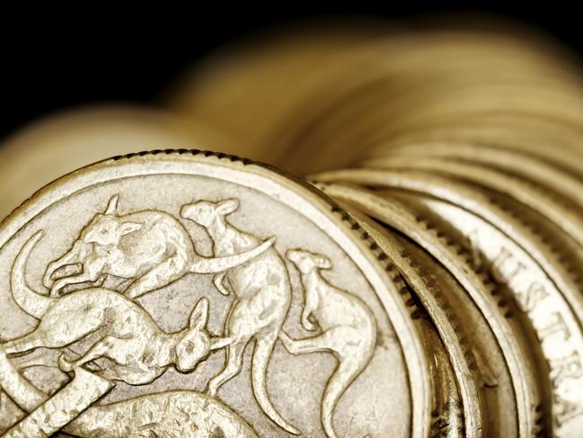 Australian one dollar coins over black background.