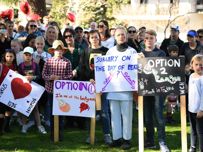 Protestors hold placards during a rally outside the Sydney Children's Hospital at Randwick in Sydney, Sunday, July 21, 2019. The rally was held in support of retaining critical paediatric cardiac surgery services at the Sydney Children's Hospital. (AAP Image/Joel Carrett) NO ARCHIVING