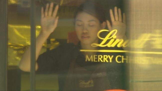 Cafe worker Elly Chen forced to stand in a Lindt café window during the siege. Picture: Seven News