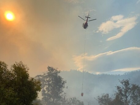 A helicopter in action as heavy smoke shrouds the sun from a fire near Lachlan on Tuesday evening. Picture: SUPPLIED