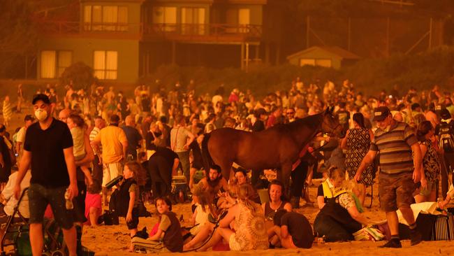 Locals seek refuge on the beach as the fire approaches. Picture: Alex Coppel.