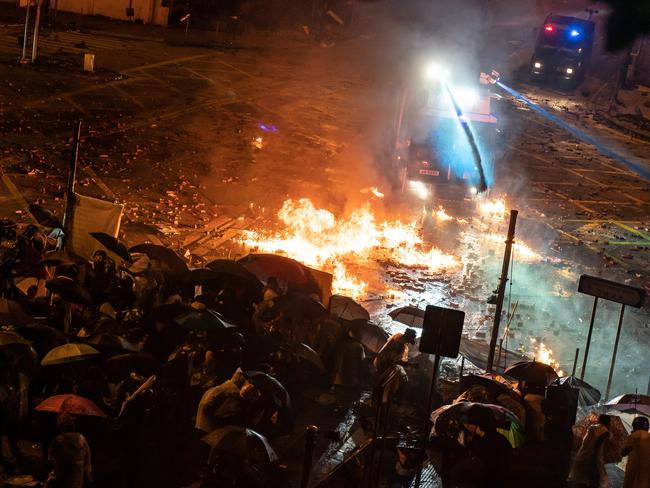 Protesters throw fire bomb as police fire water canon during a clash at The Hong Kong Poytechnic University. Picture: Getty