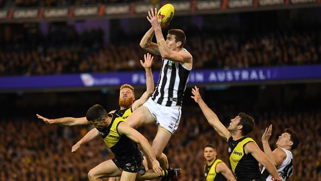 Mason Cox flies over Trent Cotchin for one of his eight contested marks. Picture: AAP