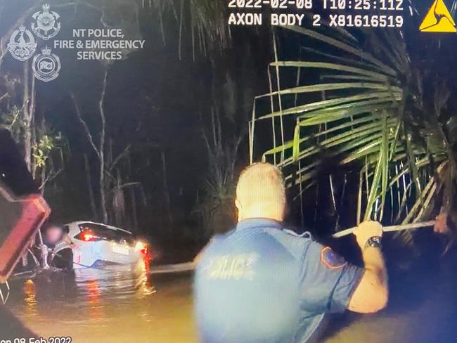 Emergency Services personnel rescue the driver of a car that was swept away in flood water after the driver attempted to cross a submerged rural road in the Virginia area. Picture: NT Police