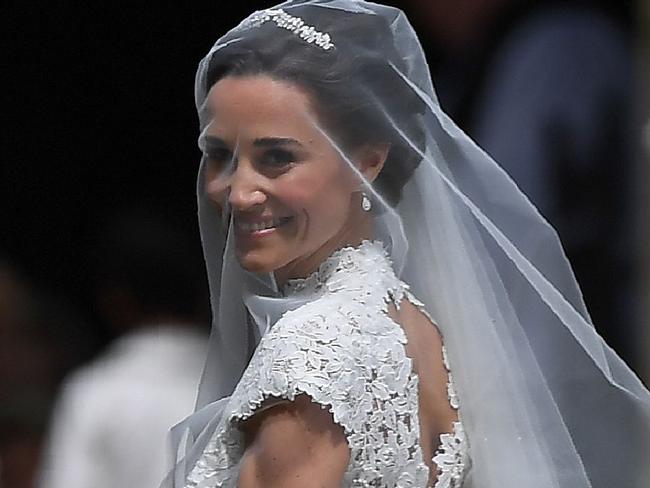 Pippa Middleton, (R) is escorted by her father Michael Middleton, as she arrives for her wedding to James Matthews at St Mark's Church in Englefield, west of London, on May 20, 2017. Pippa Middleton hit the headlines with a figure-hugging outfit at her sister Kate's wedding to Prince William but now the world-famous bridesmaid is becoming a bride herself. Once again, all eyes will be on her dress as the 33-year-old marries financier James Matthews on Saturday at a lavish society wedding where William and Kate's children will play starring roles. / AFP PHOTO / POOL / Justin TALLIS