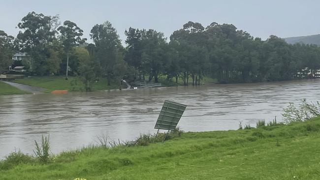 A sign on the banks of the Nepean river is still bent from floods earlier in the year.