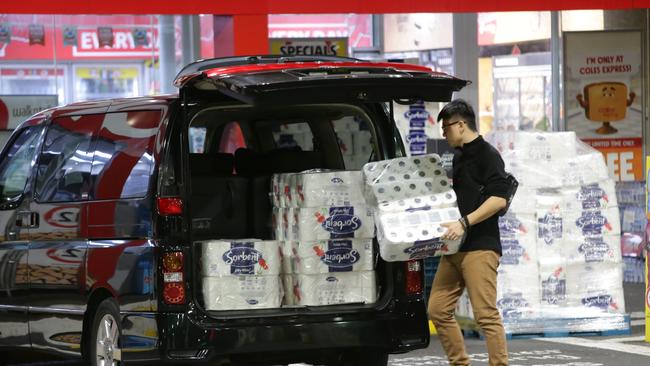 A man loads up on toilet paper outside a Coles Express petrol station in Sydney. Picture: Bill Hearne