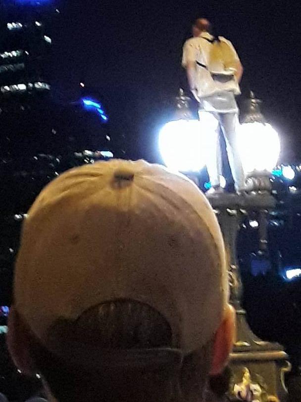 The man on top of the lamp post on the Princess Bridge. Picture: Supplied