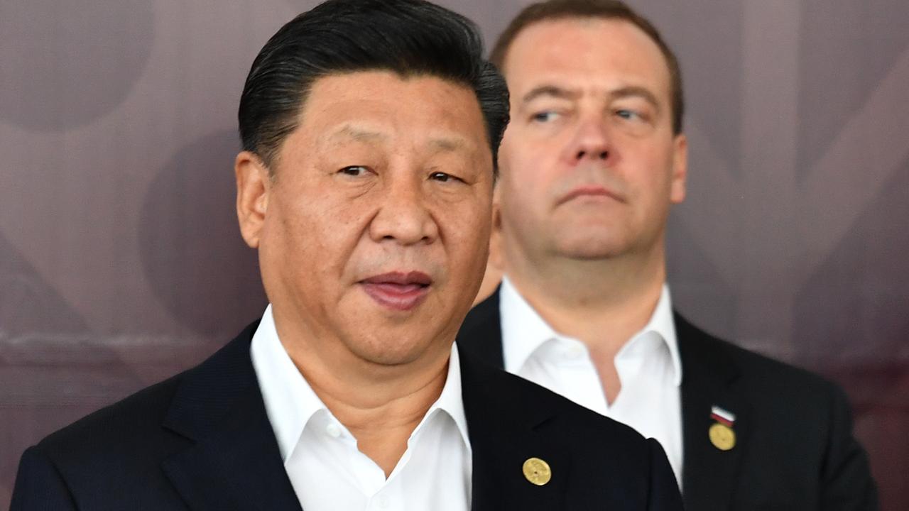 Xi Jinping and Russia's Prime Minister Dmitry Medvedev wait for the group photo at APEC. Picture: Mick Tsikas/AAP