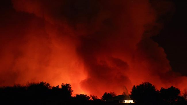 A sprinkler is utilized at a building as the Palisades Fire burns near the Mandeville Canyon neighbourhood. Picture: Getty