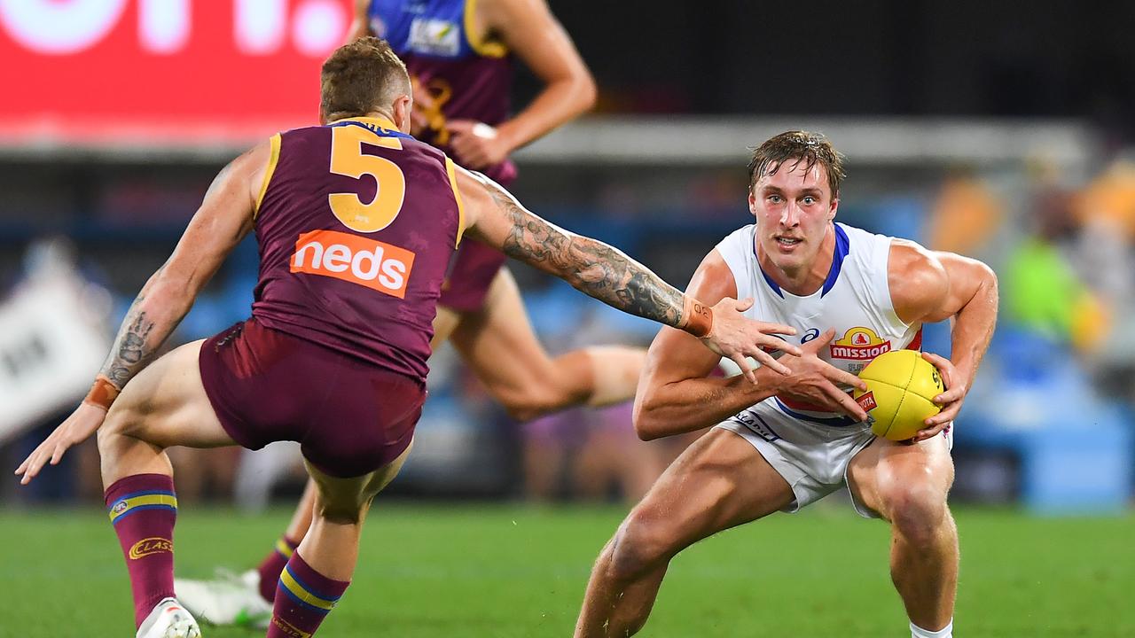 BRISBANE, AUSTRALIA – SEPTEMBER 04: Roarke Smith of the Bulldogs controls the ball under pressure from Mitch Robinson of the Lions during the AFL 1st Semi Final match between the Brisbane Lions and the Western Bulldogs at The Gabba on September 04, 2021 in Brisbane, Australia. (Photo by Albert Perez/AFL Photos via Getty Images)