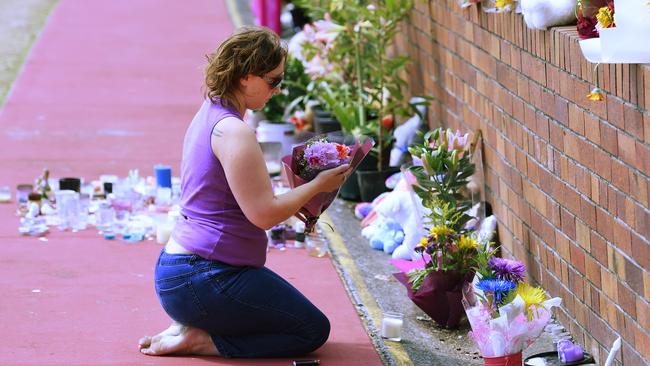 A mourner lays flowers outside the Dreamworld Theme Park on the Gold Coast, Friday, Oct. 28, 2016. (AAP Image/Dan Peled)