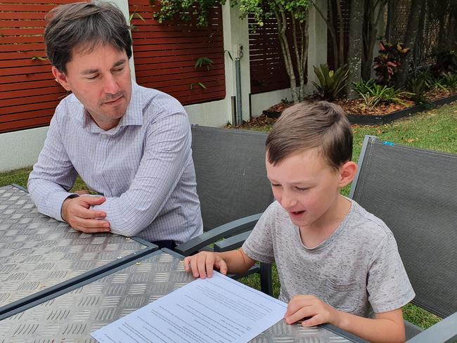 Fraser Coast Mayor George Seymour listens intently to Coen Katt, 8, reading his winning story The Little Ant.