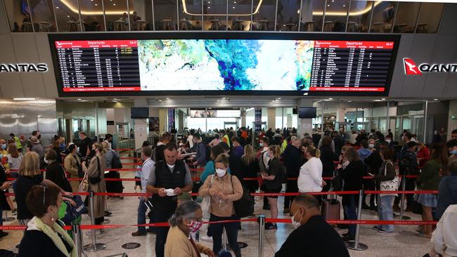 Passengers are seen at the Qantas terminal at Melbourne Airport after days of long delays. Picture: Brendan Beckett