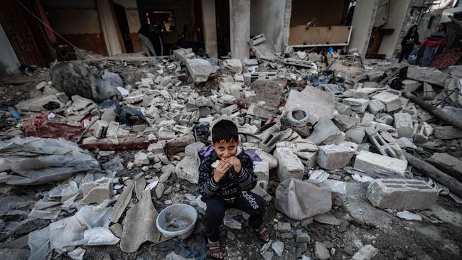 A child eats amid the rubble of destroyed buildings following Israeli bombardment in Rafah on the southern Gaza Strip. Picture: AFP