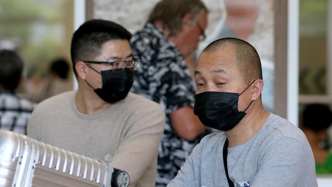 People after leaving the arrivals hall wearing face masks at the Brisbane International Airport on Tuesday, flight from China and other destinations, possibly because of coronavirus outbreak. Picture: Steve Pohlner/AAP