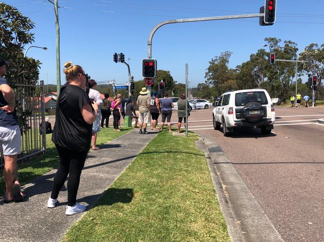 A group of onlookers gathered at the northern end of Minnesota Rd, Hamlyn Terrace, at the intersection of Warnervale Rd, watching as police search for a man following a pursuit and shooting. Picture: Richard Noone