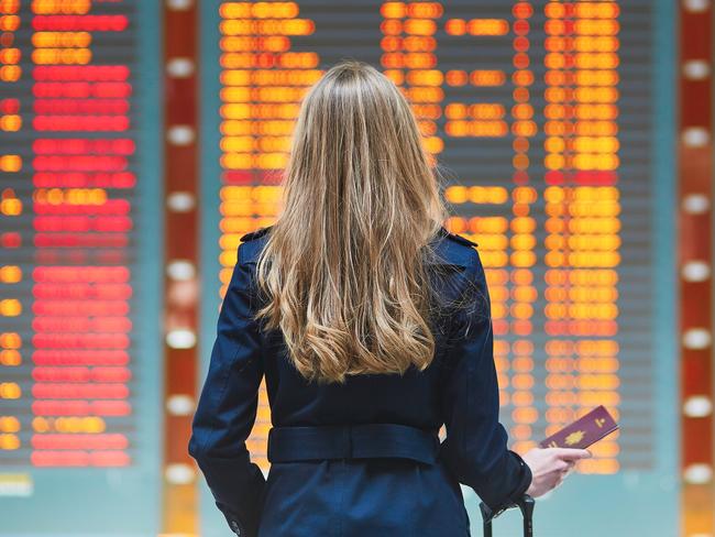 Woman looking at the flight information board.