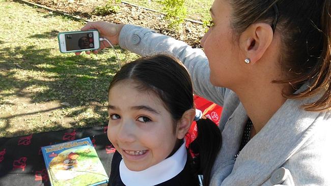 Emma Quijano with mum, Paula Lopez, while speaking to her grandmother in Colombia Luz Jaramilloin Columbia on FaceTime.