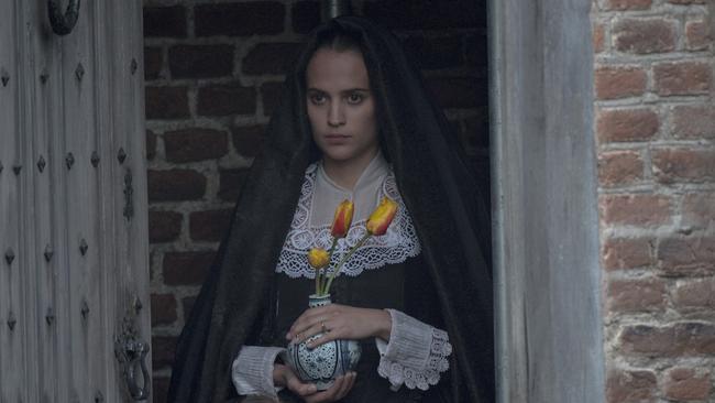 Alicia Vikander carrying some tulips in a high-octane action sequence from Tulip Fever.