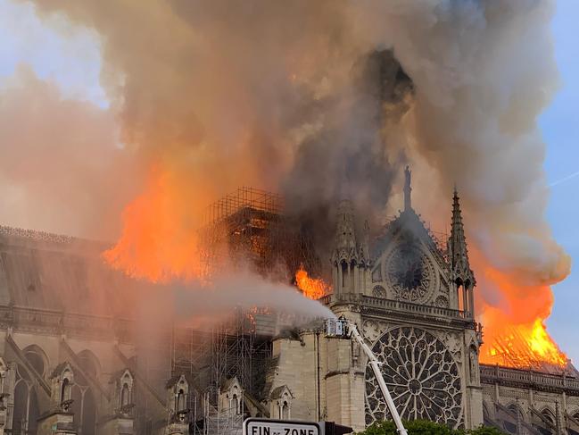 Flames and smoke are seen billowing from the roof at Notre-Dame Cathedral in Paris on April 15, 2019. - A fire broke out at the landmark Notre-Dame Cathedral in central Paris, potentially involving renovation works being carried out at the site, the fire service said.Images posted on social media showed flames and huge clouds of smoke billowing above the roof of the gothic cathedral, the most visited historic monument in Europe. (Photo by Patrick ANIDJAR / AFP)
