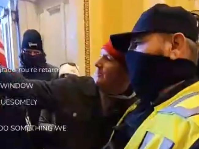 A US Capitol building police officer poses for a selfie with one of the insurrectionists who helped storm the US Capitol building.