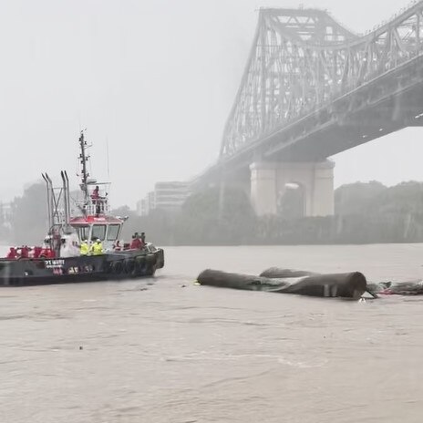 A tugboat tries to save the man after his houseboat flipped. Picture: Lucas Eckersley