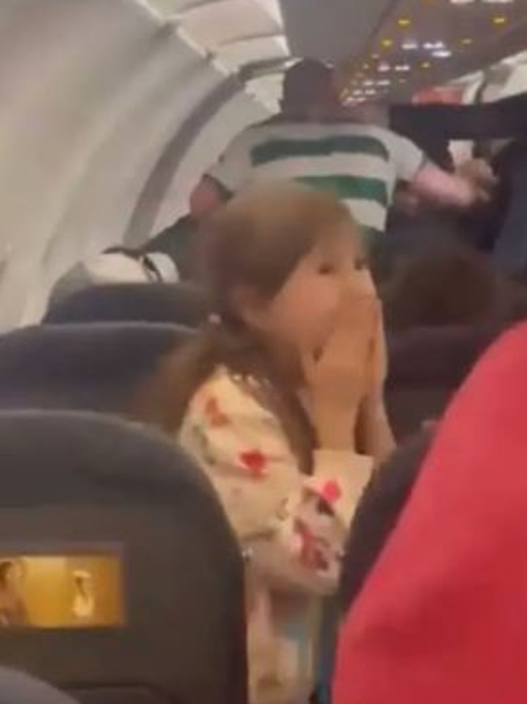A little girl can be seen anxiously covering her face while watching the fight unfold.