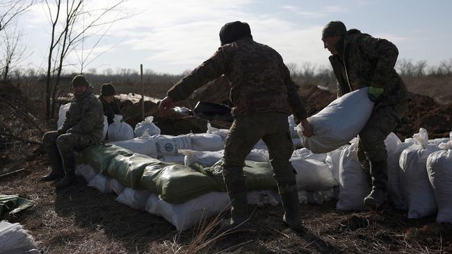 Ukrainian servicemen pile up earthbags to build a fortification not far from town of Avdiivka in the Donetsk region. Picture: AFP