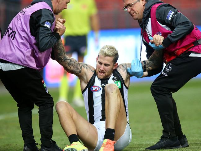 Jeremy Howe of the Magpies is assisted from the field after being injured during the Round 4 AFL Match between the GWS Giants and the Collingwood Magpies at Giants Stadium in Sydney, Friday, June 26, 2020. (AAP Image/Mark Nolan)