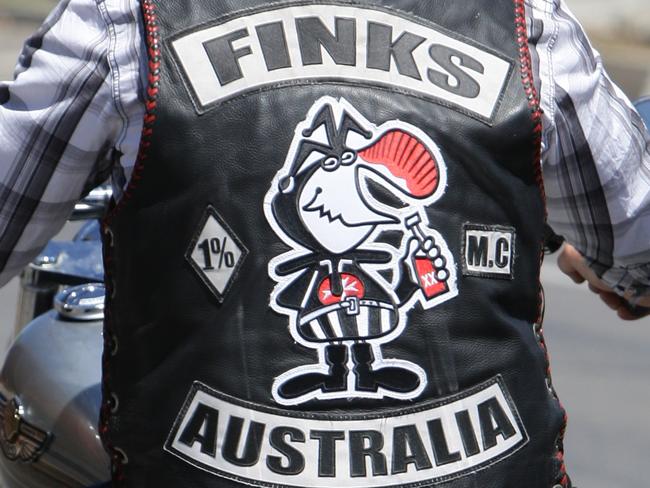 Finks Motorcycle Club and Longriders Motorcycle Club and other clubs on a run around Adelaide to visit graves of mates. Rear view of bikie wearing jacket riding on his motorcycle.