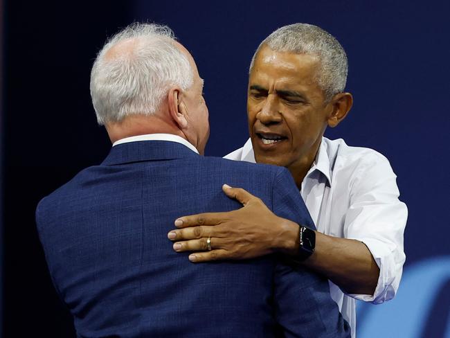 Former US President Barack Obama greets Minnesota Governor and Democratic vice presidential candidate Tim Walz during a campaign rally in support of Vice President and Democratic presidential candidate Kamala Harris, at Alliant Center in Madison, Wisconsin, on October 22, 2024. (Photo by KAMIL KRZACZYNSKI / AFP)