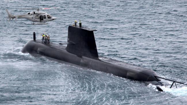 A Collins class submarine is used during a training exercise involving a helicopter.