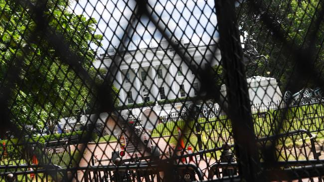 The White House is seen through several layers of recently erected security fencing and barricades from the north side of Lafayette Square.