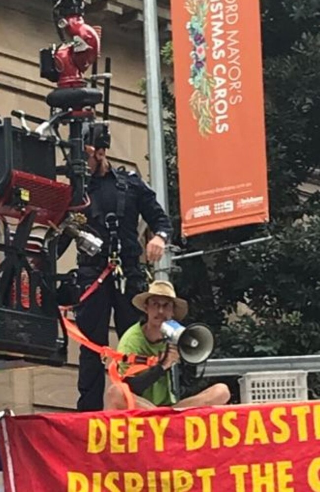 Firefighters work to remove activists from the top of a rental truck blocking traffic in the Brisbane CBD. Picture: Bianca Stone/7 News