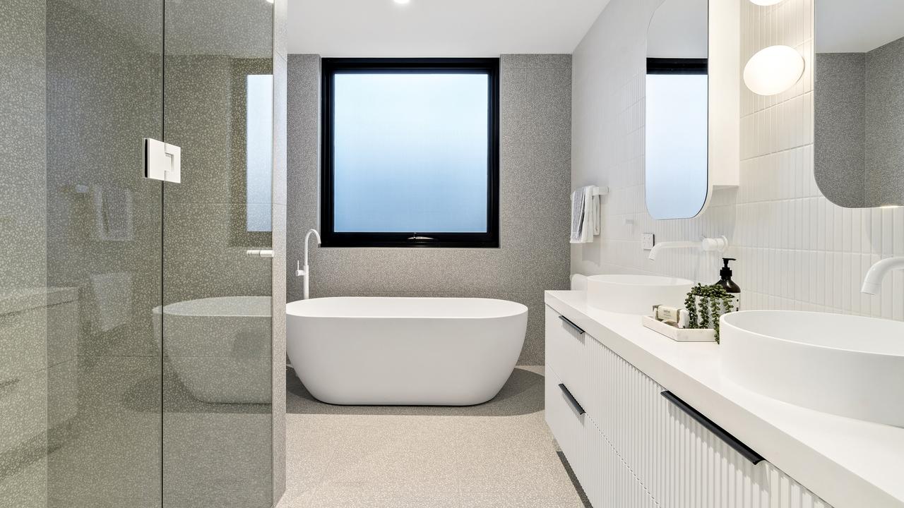 A freestanding bathtub and double vanity in one of the two bathrooms.