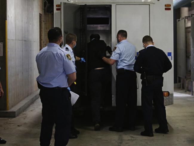 Simpson being hauled into a police van. Picture: Adam Yip