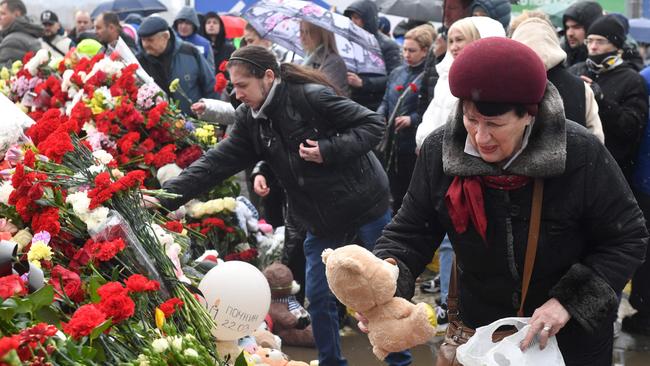 A woman places a Teddy bear at a makeshift memorial in front of the Crocus City Hall in Krasnogorsk. Picture: AFP