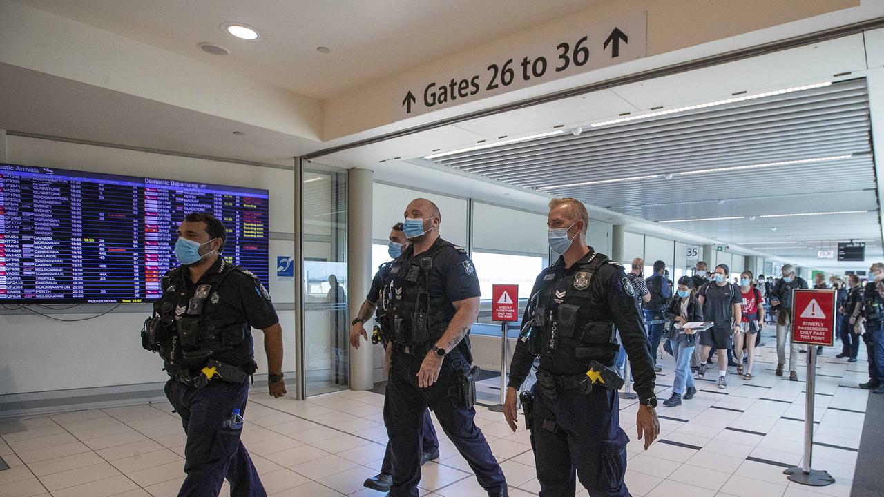 Police escort passengers from a Perth flight to a hotel quarantine bus at Brisbane domestic airport. Picture: NCA NewsWire /Jono Searle