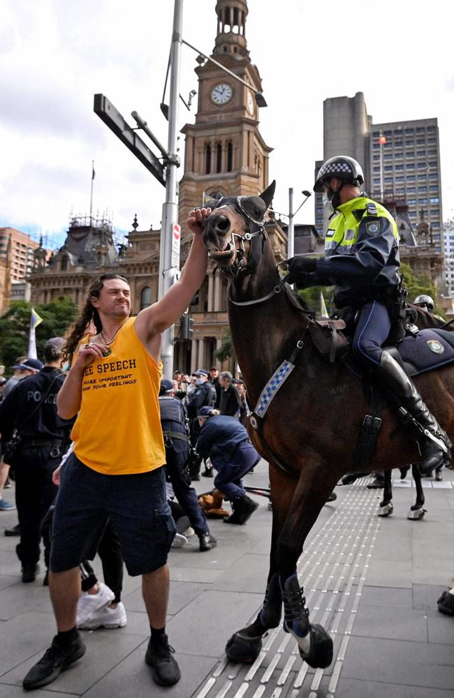 A protester tries to push away a police horse in Sydney as thousands of people gathered to demonstrate against the city's month-long stay-at-home orders. Picture: AFP