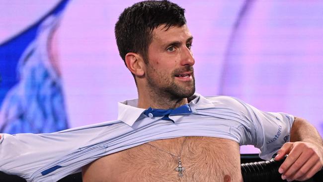 Serbia's Novak Djokovic changes his shirt during a break in his men's singles match against Croatia's Dino Prizmic on day one of the Australian Open tennis tournament in Melbourne on January 14, 2024. (Photo by WILLIAM WEST / AFP) / -- IMAGE RESTRICTED TO EDITORIAL USE - STRICTLY NO COMMERCIAL USE --