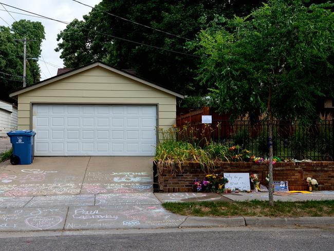 Tributes cover a driveway and brick wall near where Justine Damond was killed. Picture: Jules Ameel