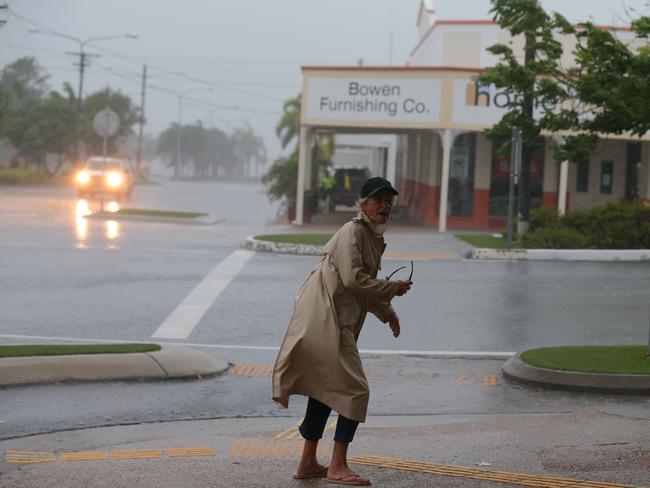 A local dashes out to take a quick look out to check the area and look at the weather while they can just after dawn in the main street of Bowen. Picture: Lyndon Mechielsen/The Australian