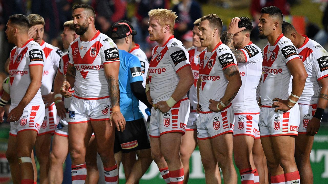 Dragons players look on after conceding a try against the Roosters