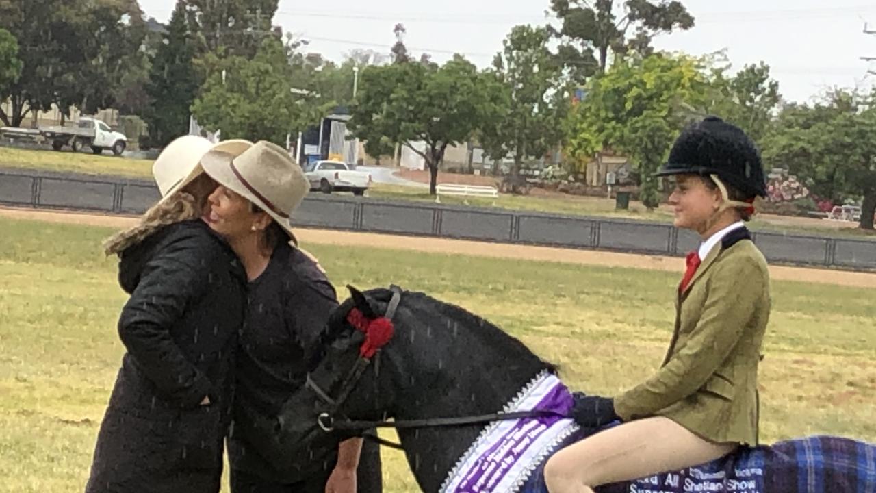 Lisa Beardsley congratulates Ester Robinson, while rider Hahana Young looks on.