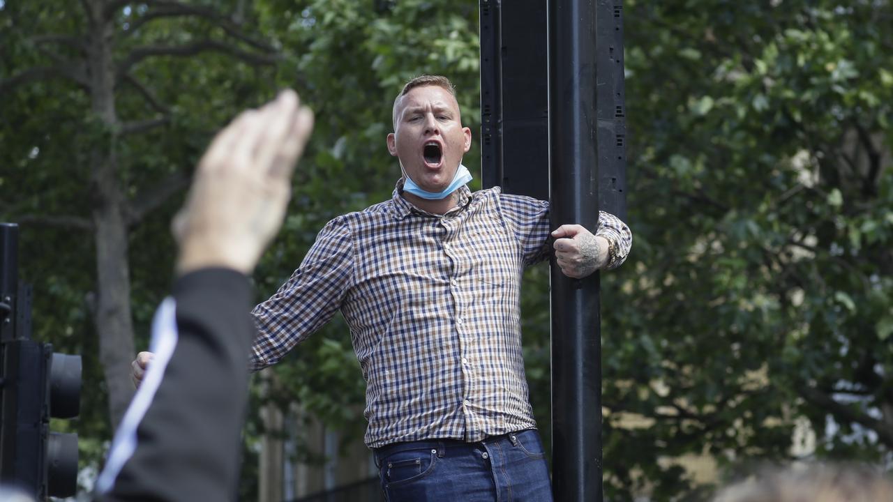 A protester climbs on a pole, chanting slogans in Whitehall. Picture: AP/Kirsty Wigglesworth