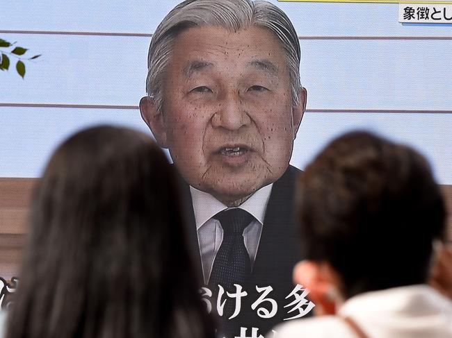 People look at a big video screen on the street as a speech by Japanese Emperor Akihito to the nation is televised in Tokyo on August 8, 2016. Emperor Akihito said on August 8 he is concerned his weakening health may make it hard to fulfil his duties, in a speech seen as signalling a possible future abdication. / AFP PHOTO / TORU YAMANAKA