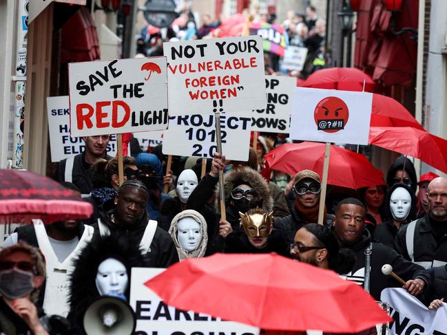 Sex workers and sympathisers take part in a demonstration to protest plans to shutter the city's historic red light district to be moved to a new erotic centre in Amsterdam on March 30, 2023. - Amsterdam wants to move legal prostitution outside the city centre's famed red light district over complaints from residents over crime and visitors' behaviour. (Photo by Kenzo TRIBOUILLARD / AFP)