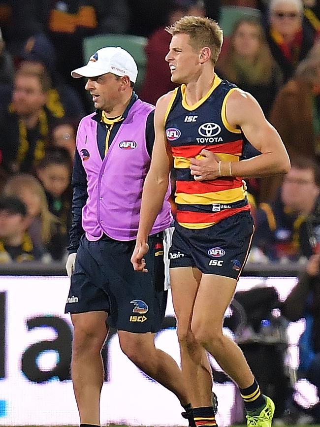 David Mackay of the Crows is helped by a trainer after a knock to the ribs against the West Coast Eagles on Saturday. Picture: Daniel Kalisz/Getty Images